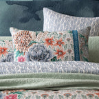 Floral and paisley patterned pillows on a textured surface