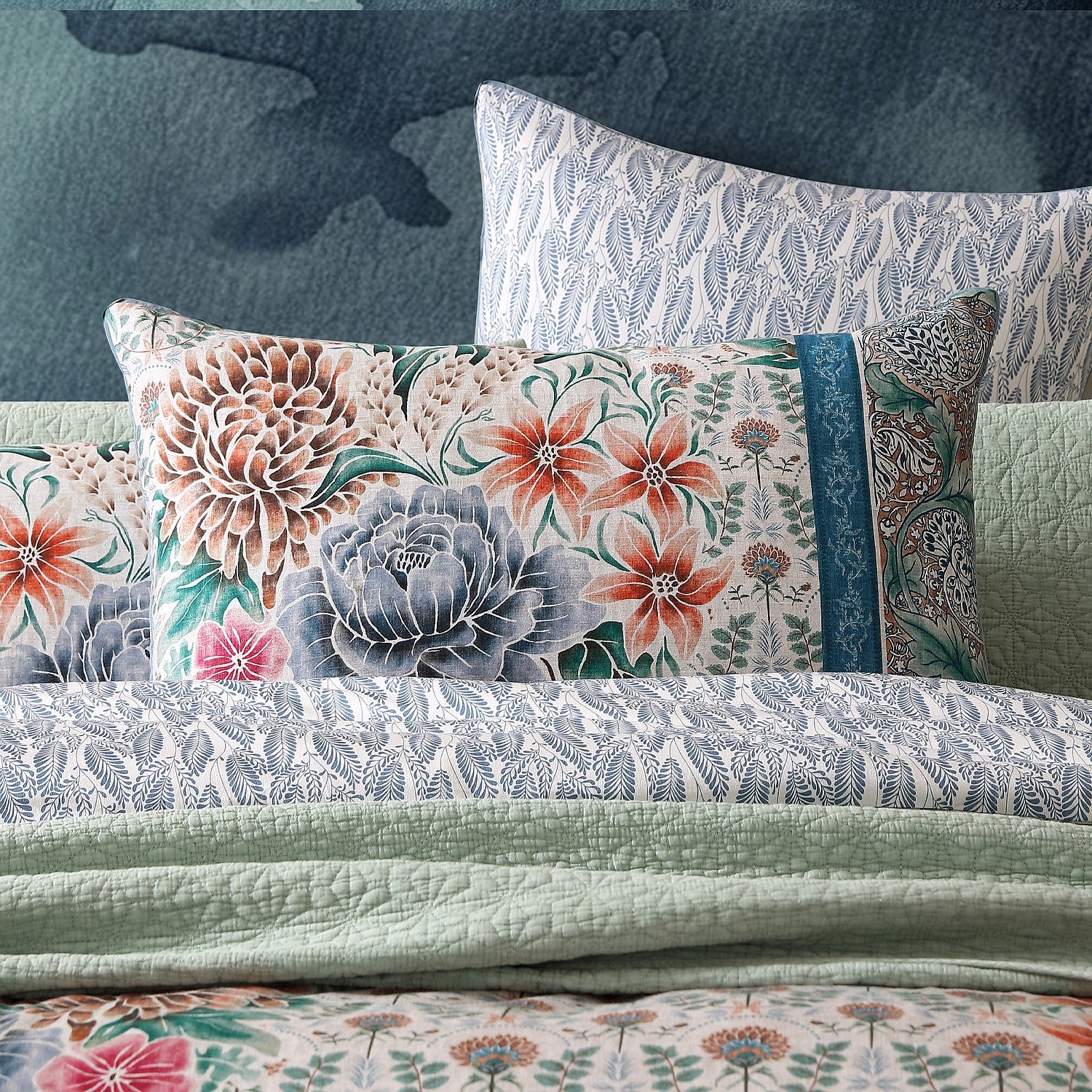 Floral and paisley patterned pillows on a textured surface