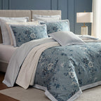 Floral bedding set on a bed with a lamp in the background
