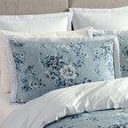 Floral patterned pillow on a bed with matching bedding