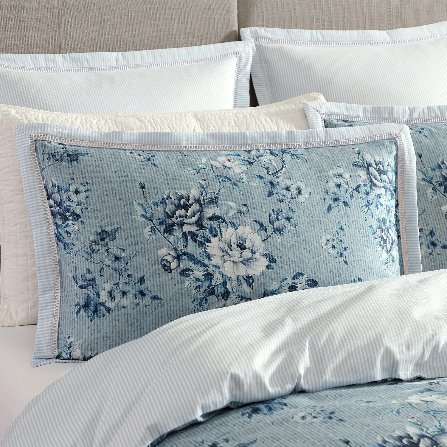 Floral patterned pillow on a bed with matching bedding