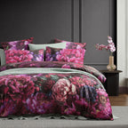 Floral bedding set on a bed with a dark gray wall and side table in the background.