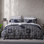 Bed with floral patterned comforter and pillows against a neutral wall.