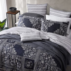 Bed with patterned bedding and pillows in a bedroom setting