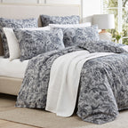 Floral patterned bedding set on a bed in a bright room.