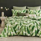 Bed with green leaf pattern bedding and matching pillows in a bedroom setting.