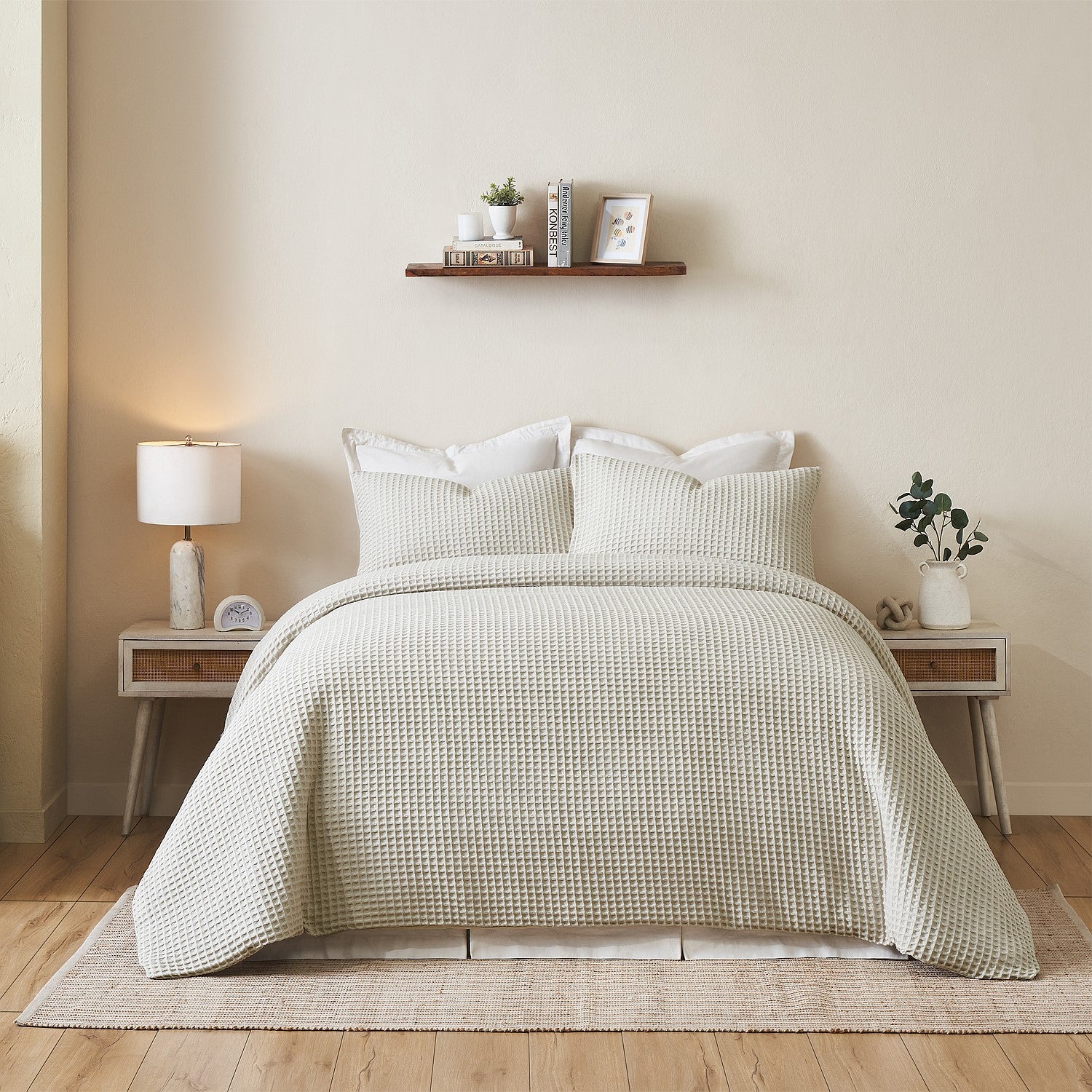 Neatly made bed with white bedding in a bedroom setting.