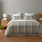 Bed with plaid bedding in a bedroom setting with wooden nightstands and decor.