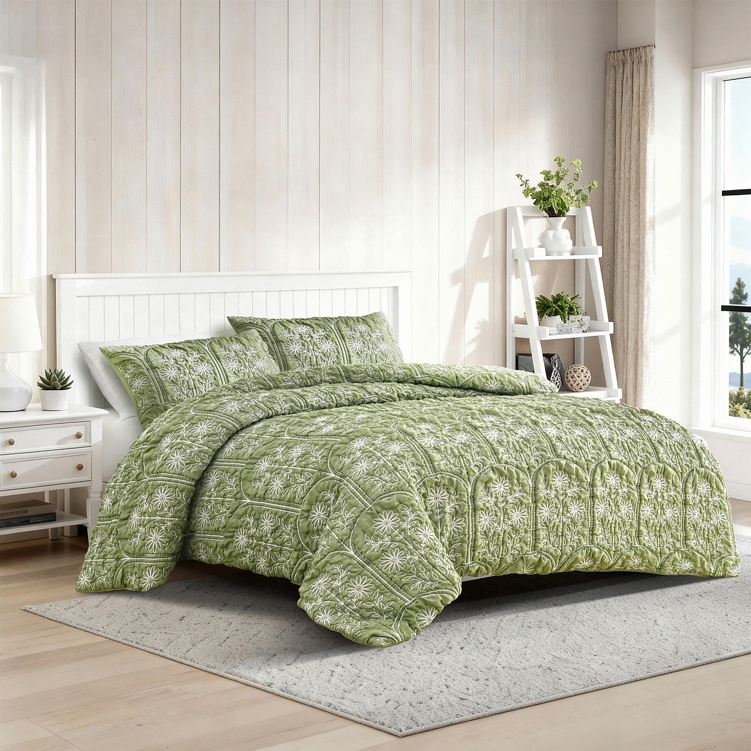 Green patterned comforter set on a bed in a bright bedroom with wooden floor and white walls.