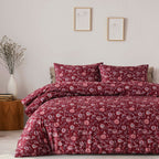 Floral patterned bedding set on a bed in a bedroom with a side table and decor.