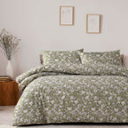 Floral patterned bedding set on a bed in a bedroom with framed artwork on the wall.