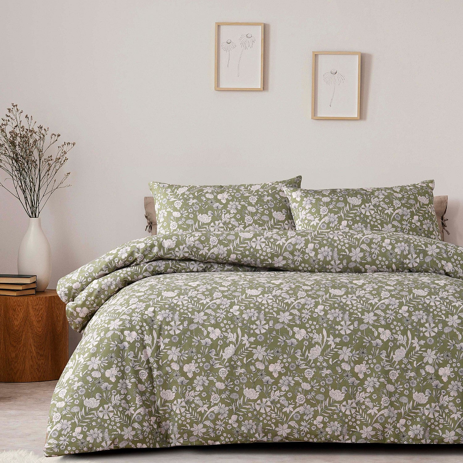 Floral patterned bedding set on a bed in a bedroom with framed artwork on the wall.