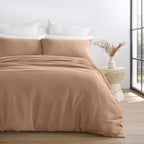 Brown bedding set on a bed with white pillows in a bright bedroom.