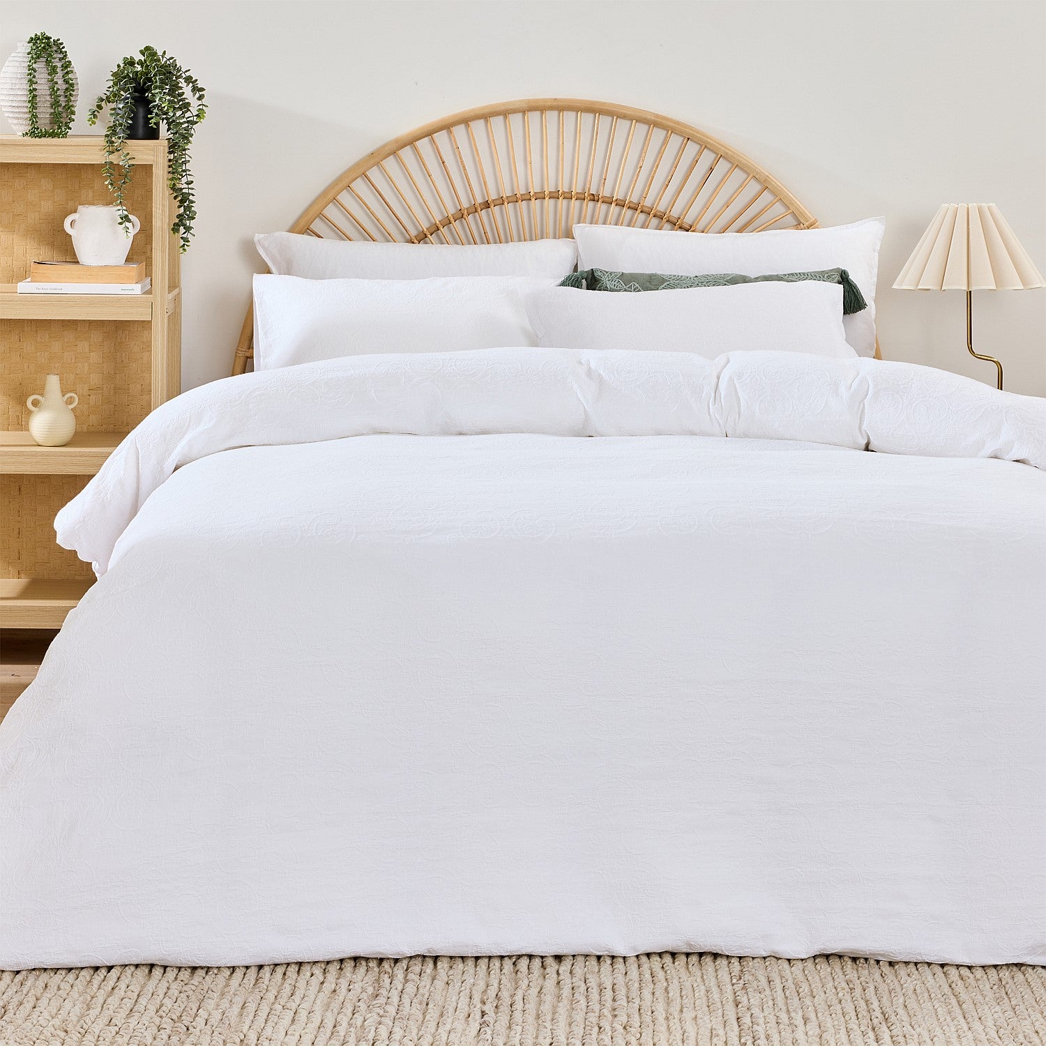 White duvet cover on a bed with a wooden headboard and shelves in the background.