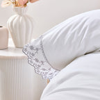 White pillow with lace trim on a neutral background