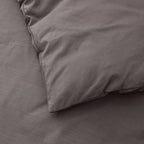 Gray bedding set with a pillow on a bed