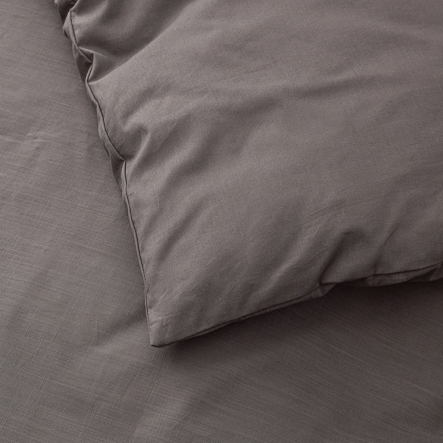 Gray bedding set with a pillow on a bed