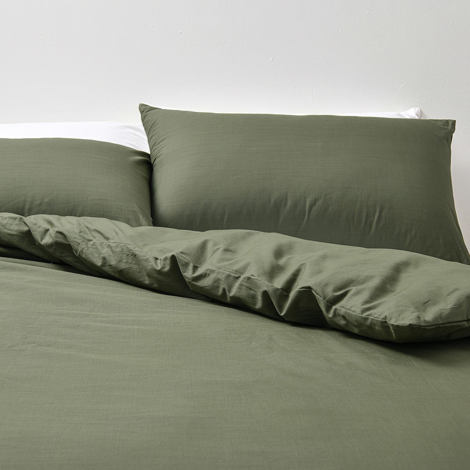 Green bedding set with pillows on a white background