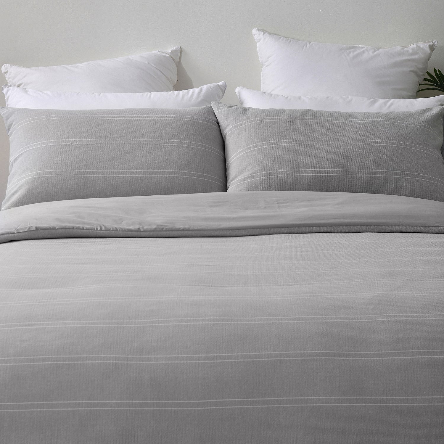 Gray bedding set with white pillows on a neutral background