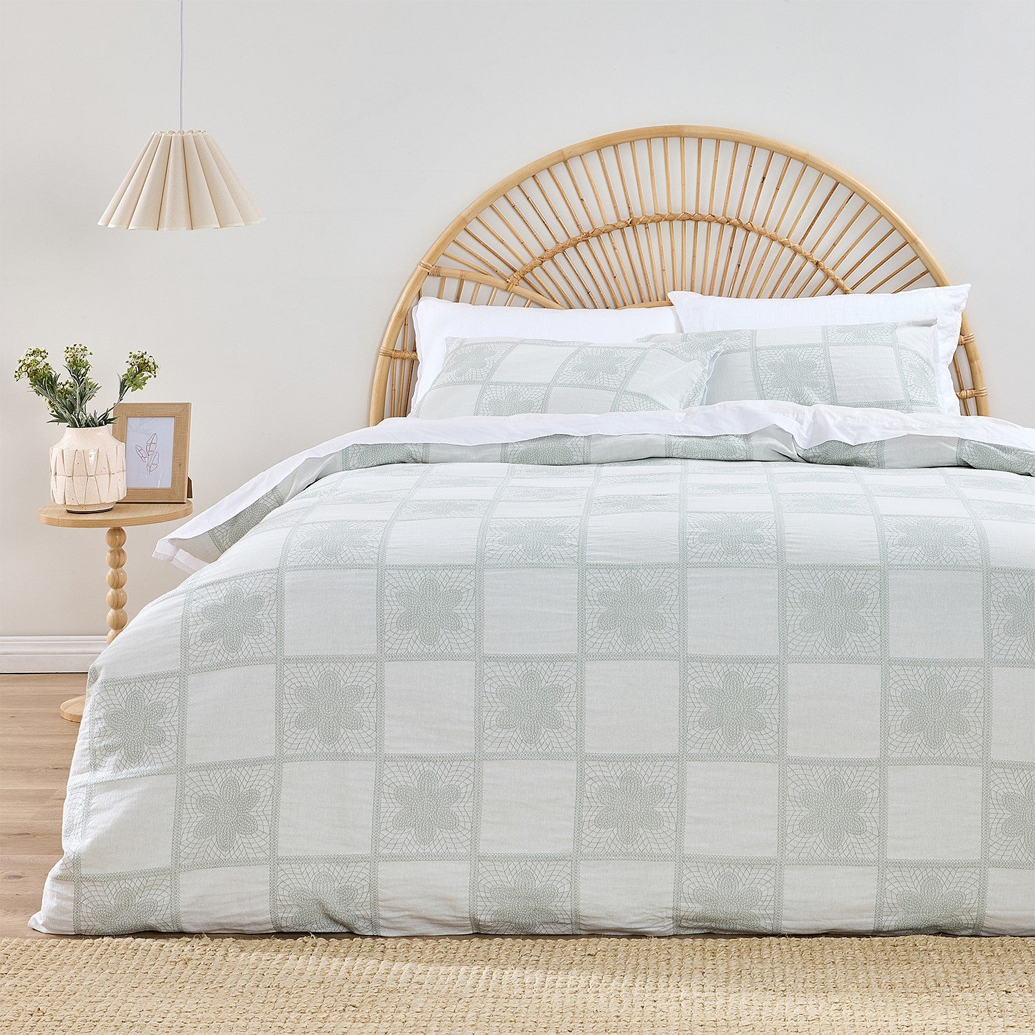 Bed with checkered duvet and wicker headboard in a room setting