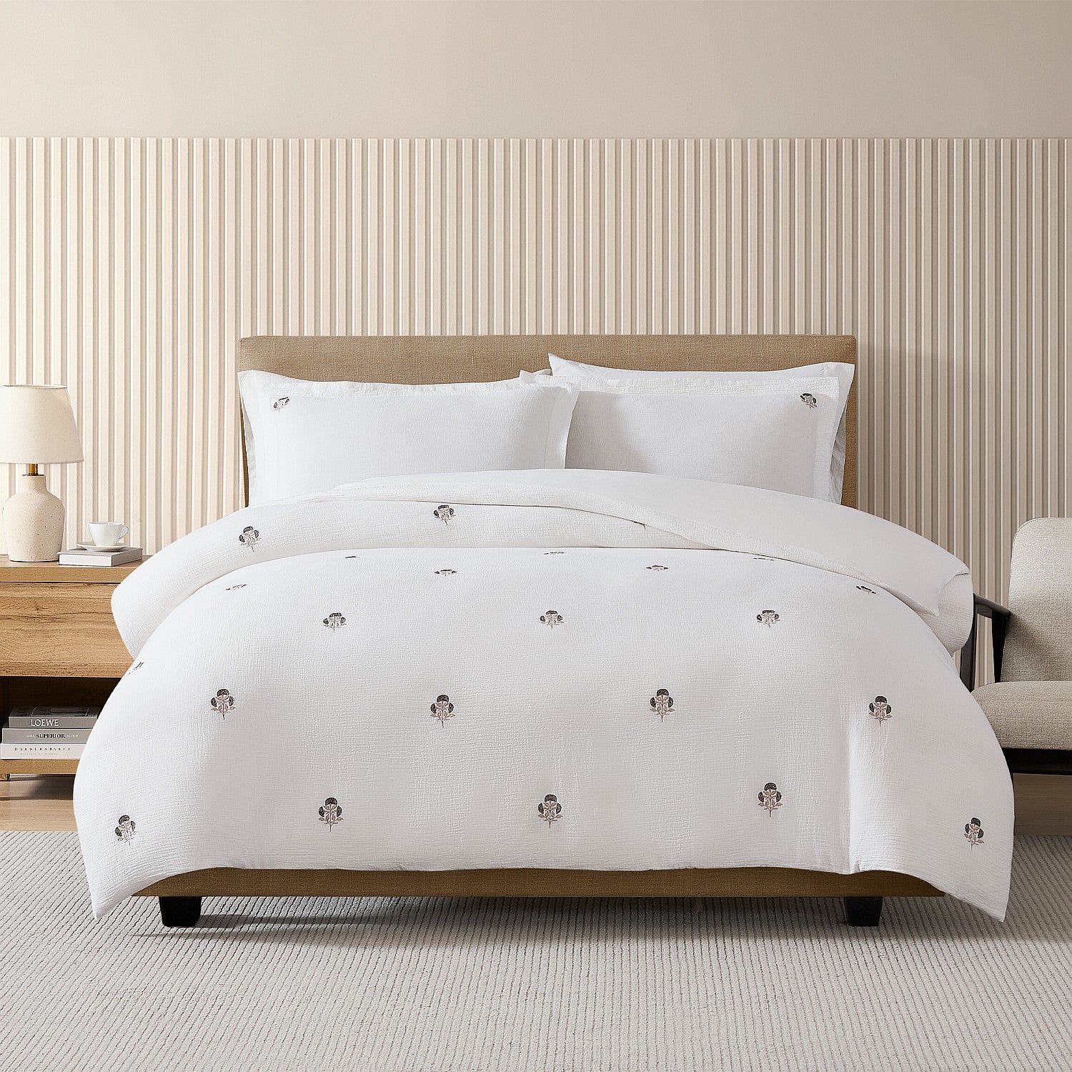 White comforter with decorative buttons on a bed in a bedroom setting.