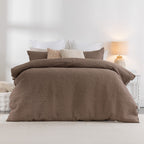 Brown textured duvet cover on a bed with white pillows and a lamp in the background.