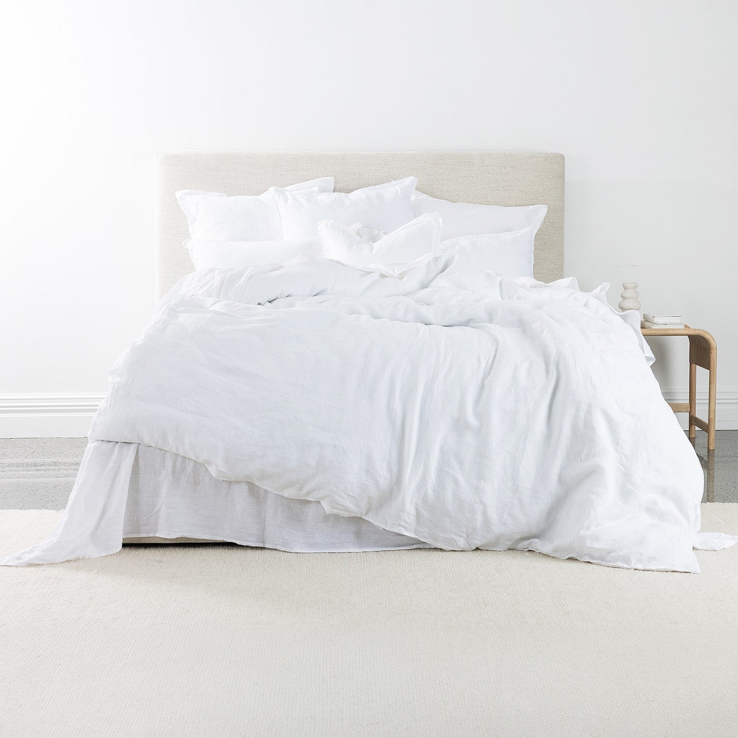 White bedding set on a bed in a minimalistic room