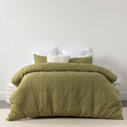 Moss embossed duvet cover set featuring an intricate medallion-inspired pattern and soft quilted texture, styled on a bed with matching pillowcases and neutral accent cushions.