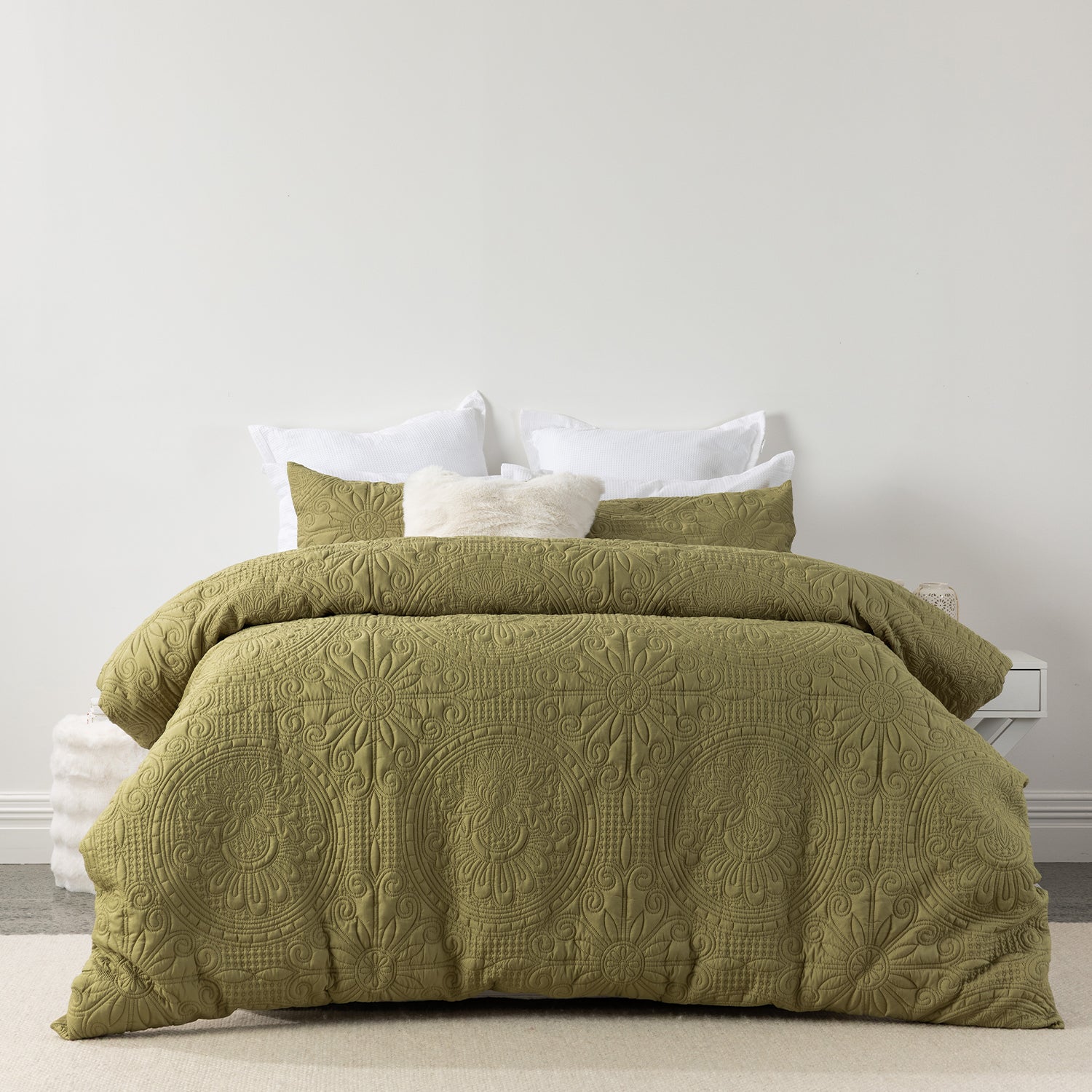 Moss embossed duvet cover set featuring an intricate medallion-inspired pattern and soft quilted texture, styled on a bed with matching pillowcases and neutral accent cushions.