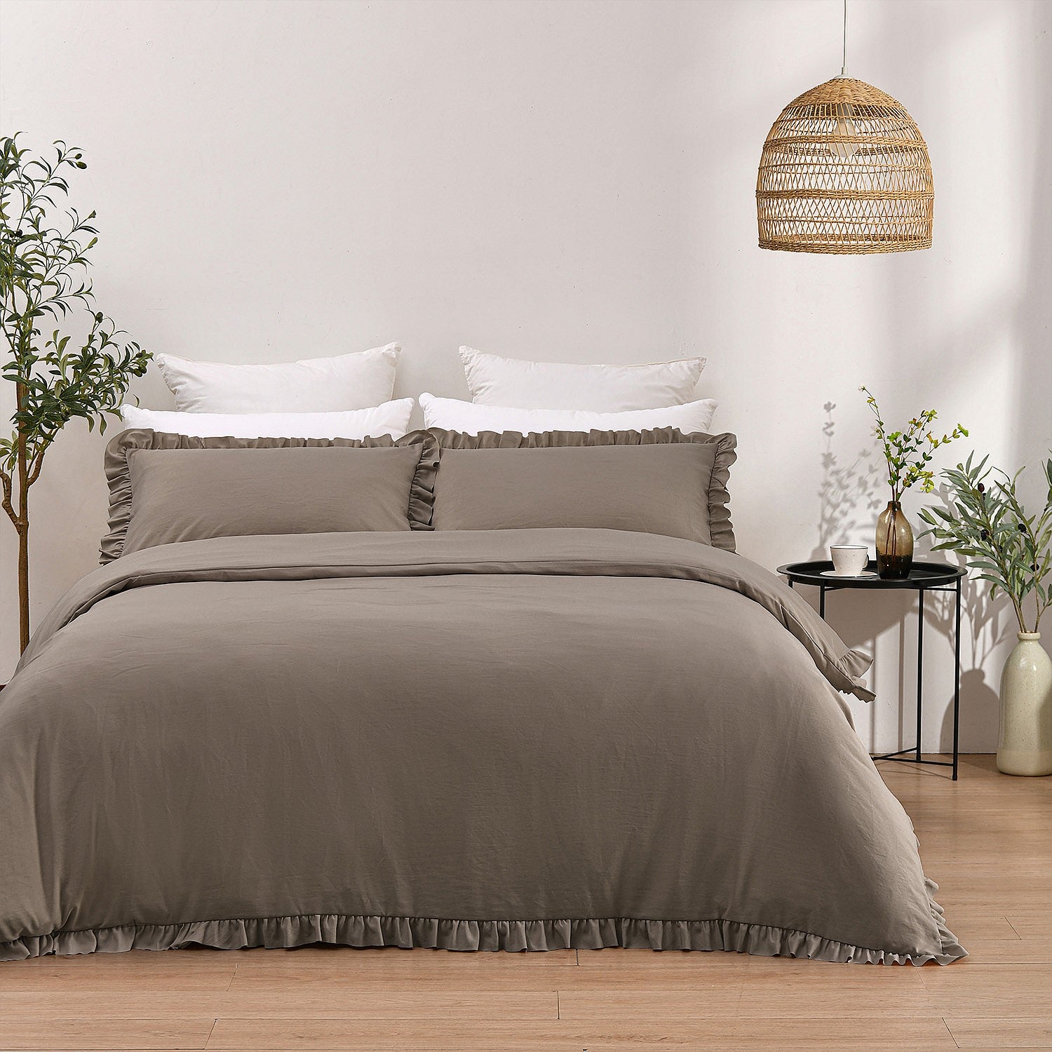 Neatly made bed with gray bedding in a bedroom setting.