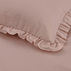 Pink pillow with ruffled edge on a matching pink background