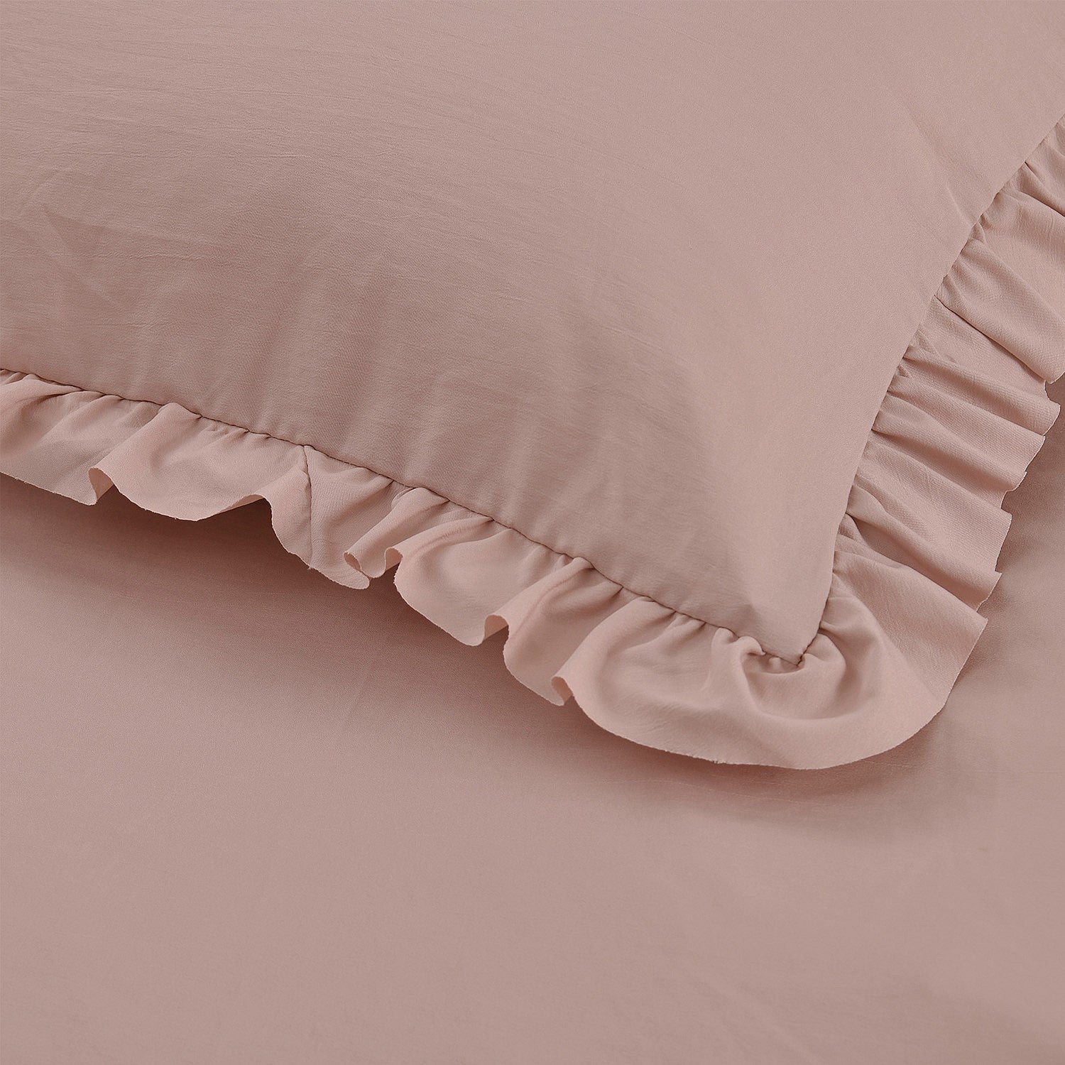 Pink pillow with ruffled edge on a matching pink background