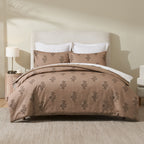 A warm pecan-toned duvet cover set featuring a delicate botanical print is beautifully styled on a contemporary bed, creating a cosy and sophisticated bedroom retreat.