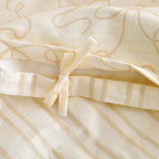 Close-up of the external bow tie closure and reversible striped reverse on the lemon and cream cotton duvet cover set.