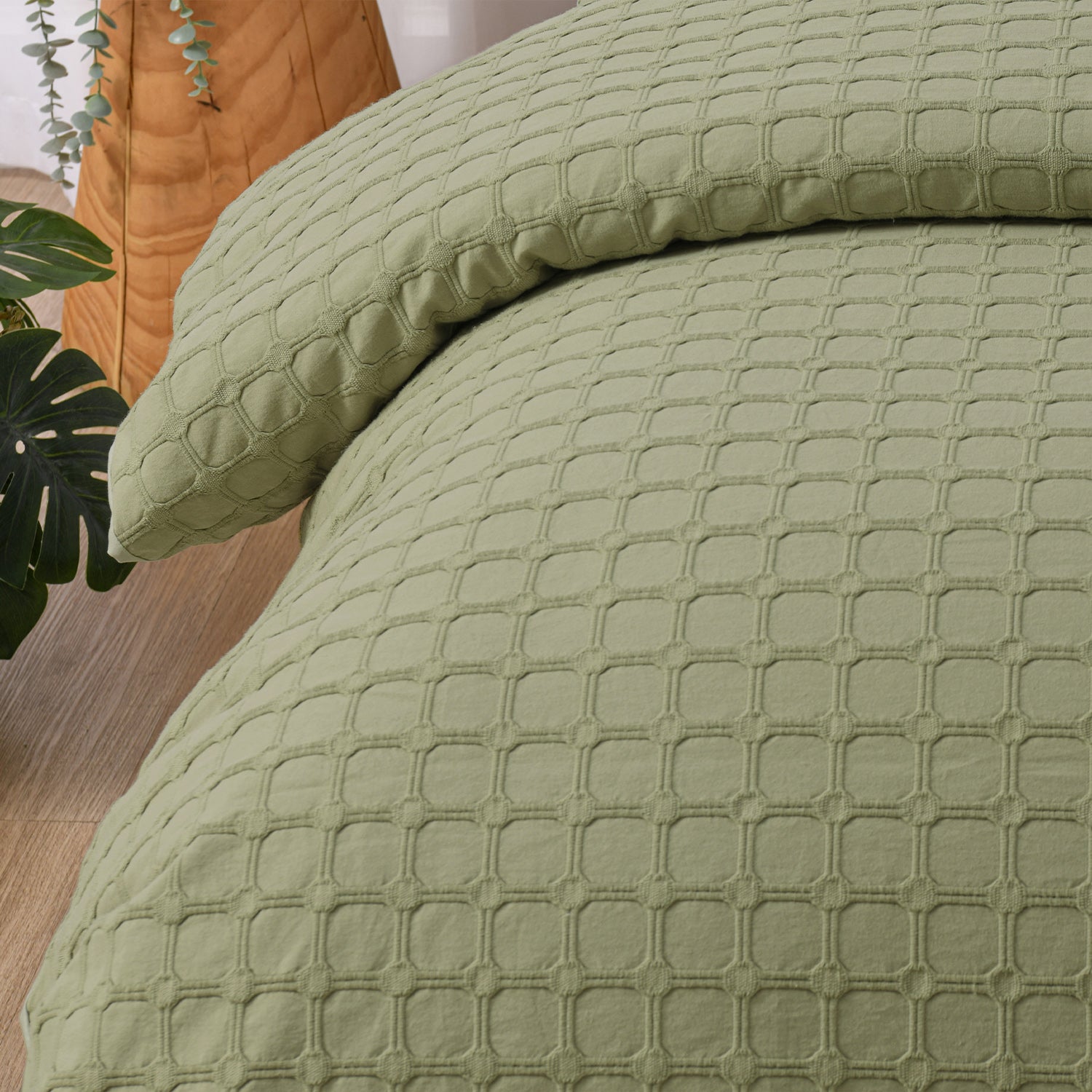 Close-up of the olive Fieldcrest Maison cotton duvet cover and pillowcase highlighting the raised geometric textured design.