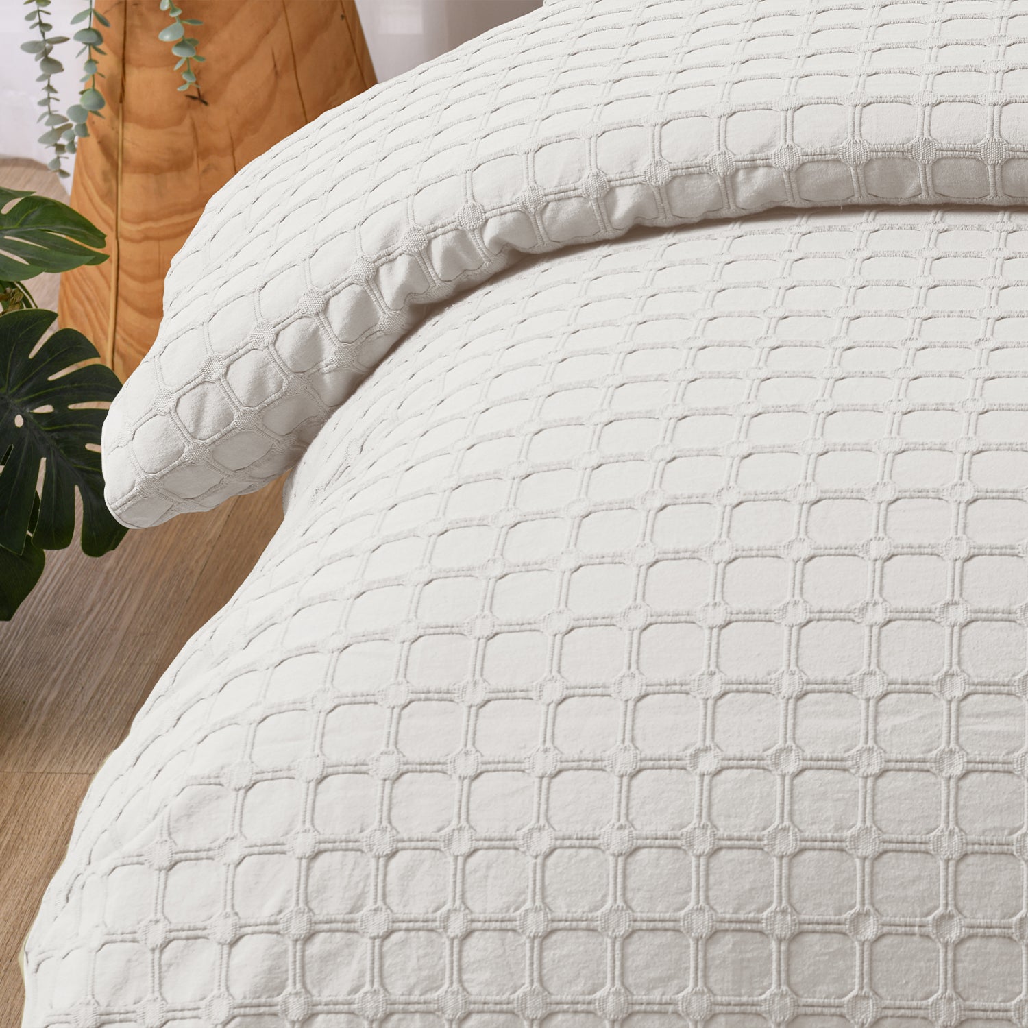 Close-up of the white Fieldcrest Maison cotton duvet cover and pillowcase highlighting the raised geometric textured design.