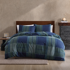 Bed with blue and green plaid comforter in a bedroom setting.