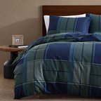 Bed with blue and green plaid bedding in a bedroom setting.