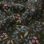 Floral patterned fabric with pink, blue, and red flowers on a dark green background.