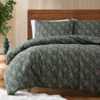 Floral patterned bedding set on a bed with a wooden headboard.