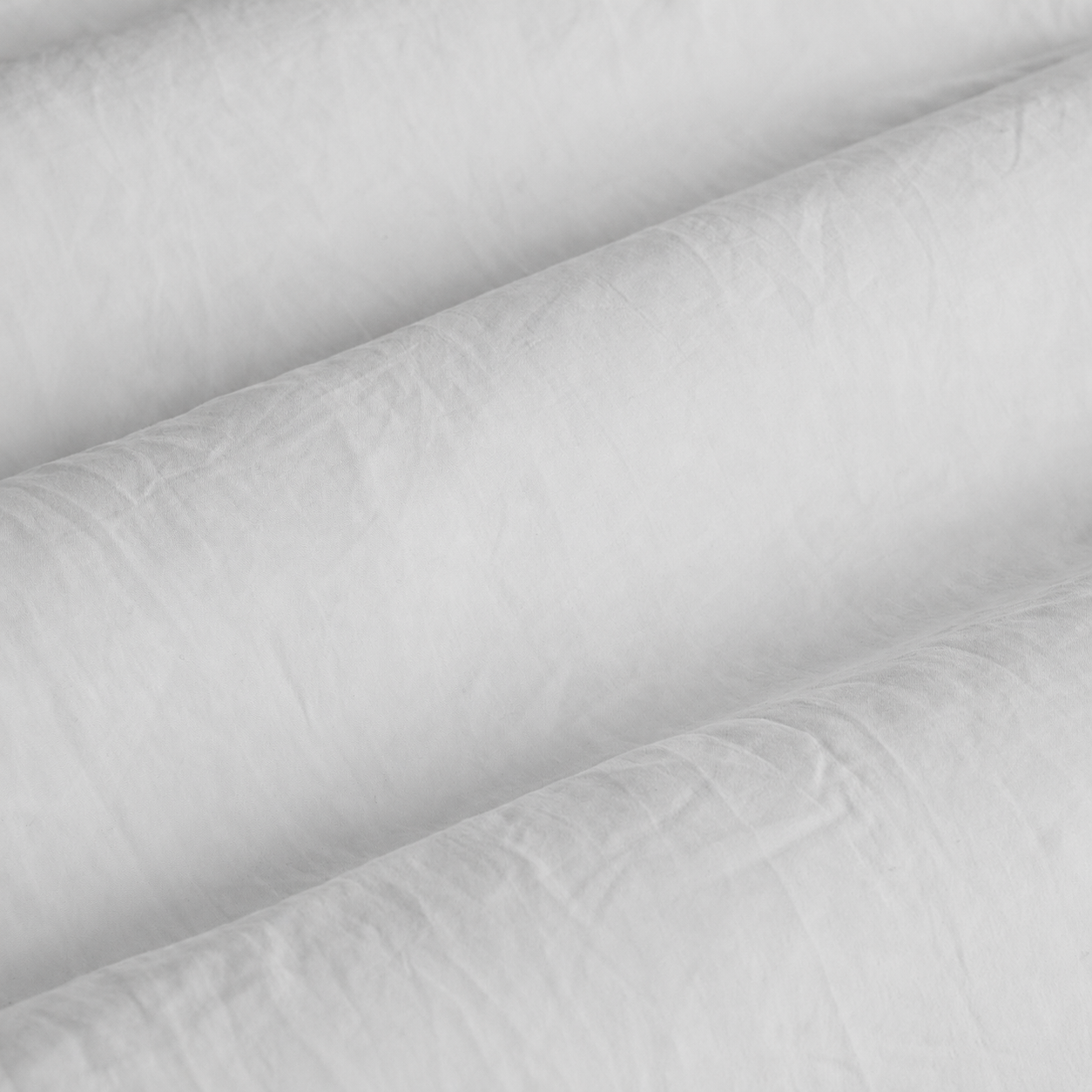 Close-up of white quilted fabric with a subtle pattern