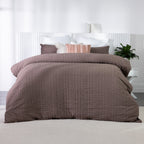 Mocha textured duvet cover set styled on a bed with coordinating mocha and blush cushions in a bright contemporary bedroom.