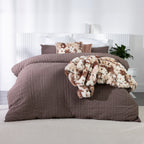 Mocha textured duvet cover set styled with a brown and cream faux fur throw and matching faux fur accent cushion in a contemporary bedroom.