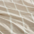 A close-up of a textured fabric with a woven grid pattern in warm beige and off-white.