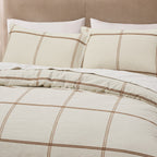 Detailed view of the Fieldcrest Ward Cotton Check Duvet Cover Set in Cream, featuring matching pillowcases and a classic brown check pattern on a soft cream background.