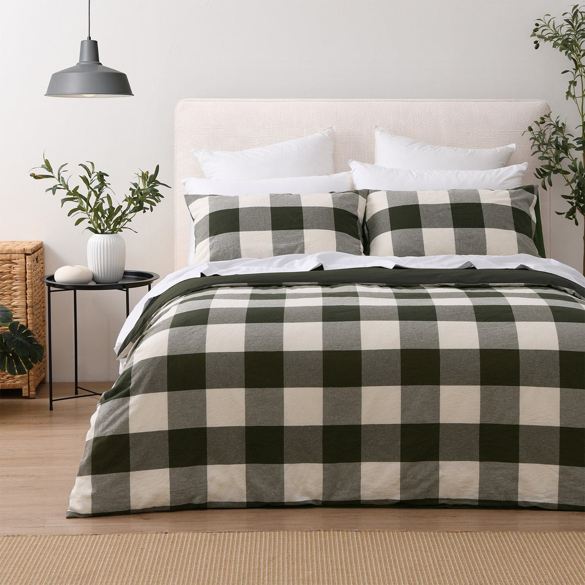 Green oversized check duvet cover set styled on a bed with two matching pillowcases, white pillows and greenery.