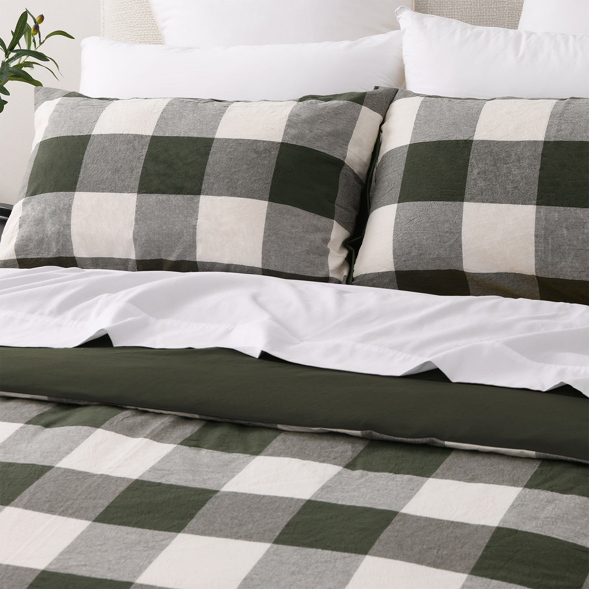 Close-up of two matching green check pillowcases with the duvet cover folded back to reveal the solid green reverse.
