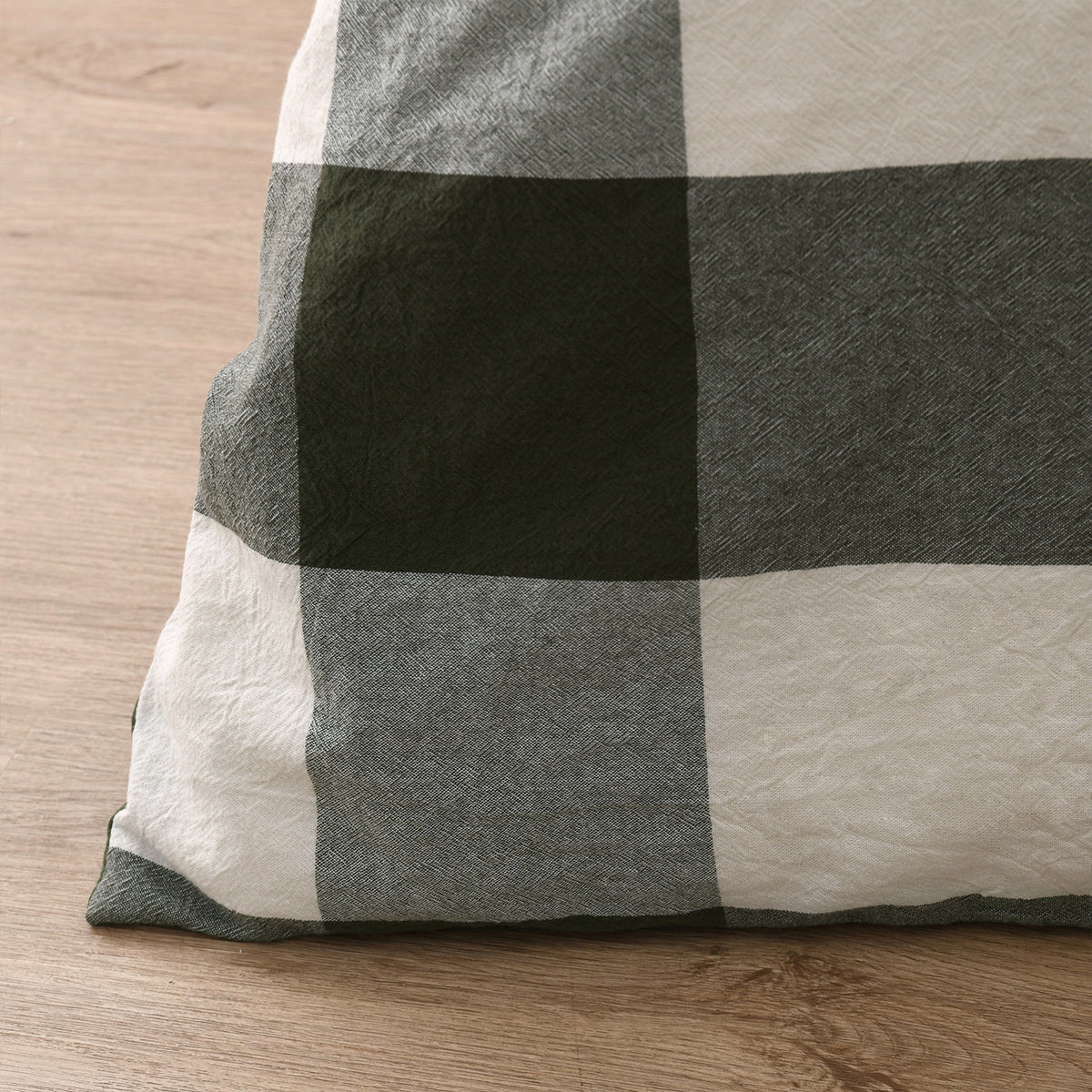 Close-up of the green, grey and neutral oversized check duvet cover showing the woven cotton texture.