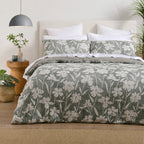 Green and white floral duvet cover set styled on a bed with matching pillowcases, white pillows and natural décor.