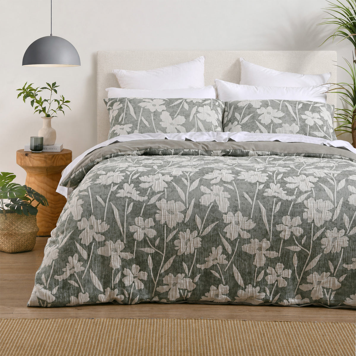 Green and white floral duvet cover set styled on a bed with matching pillowcases, white pillows and natural décor.